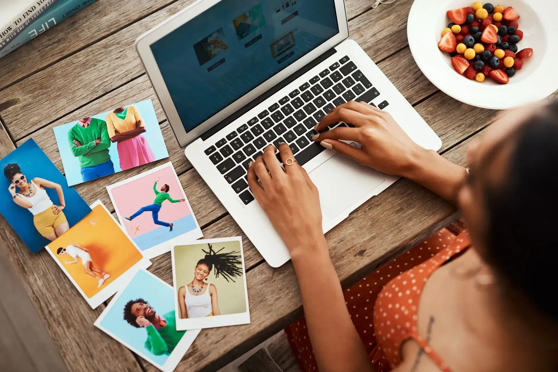 A woman is sitting at a table using a laptop computer.