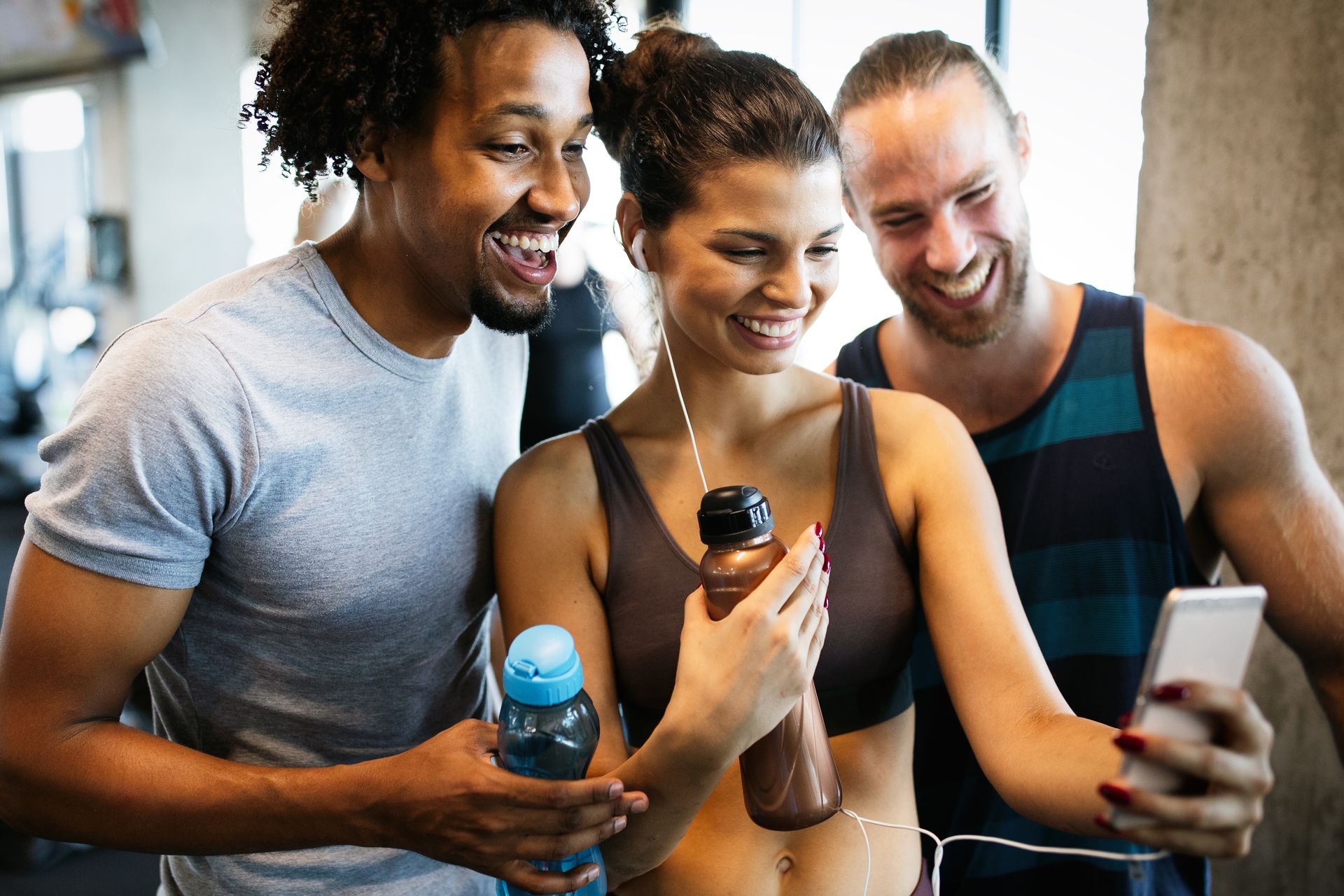 A group of people are taking a selfie in a gym.