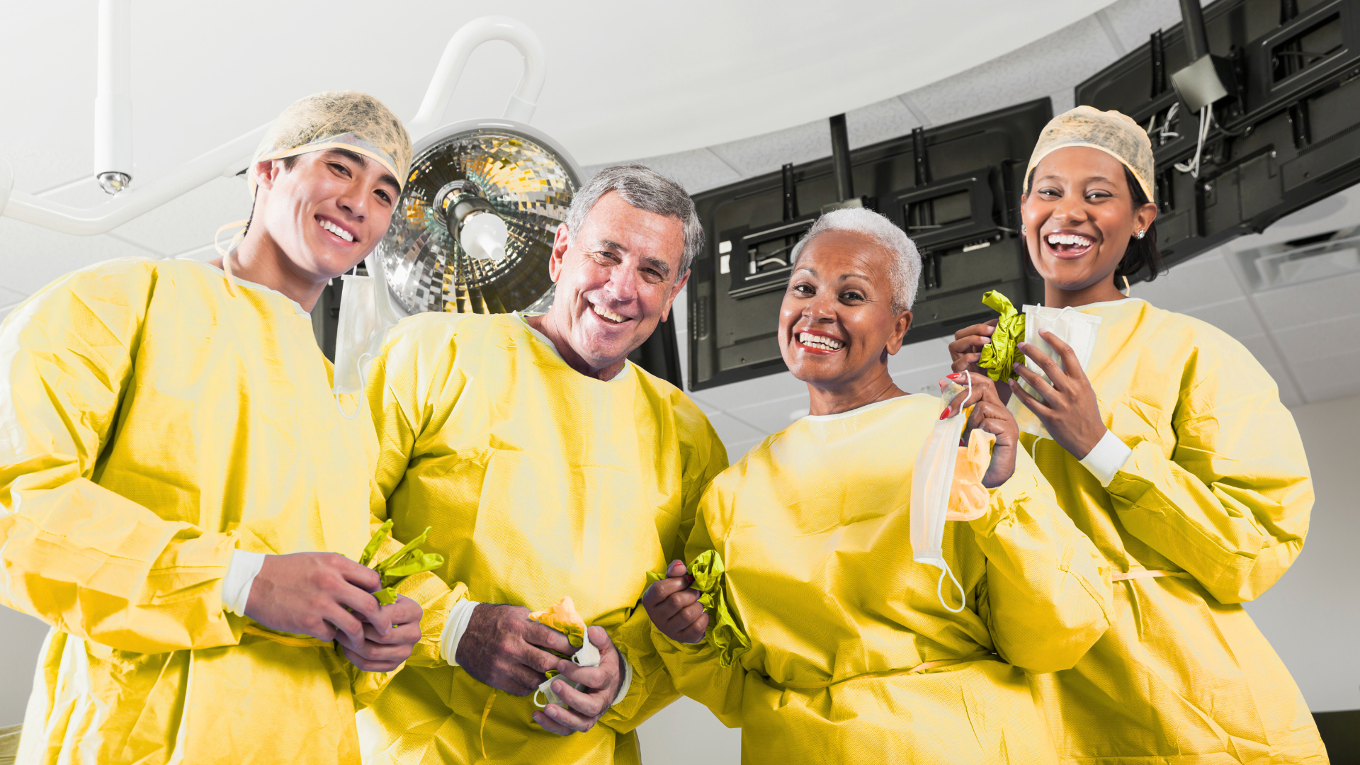 A group of surgeons are posing for a picture in an operating room.