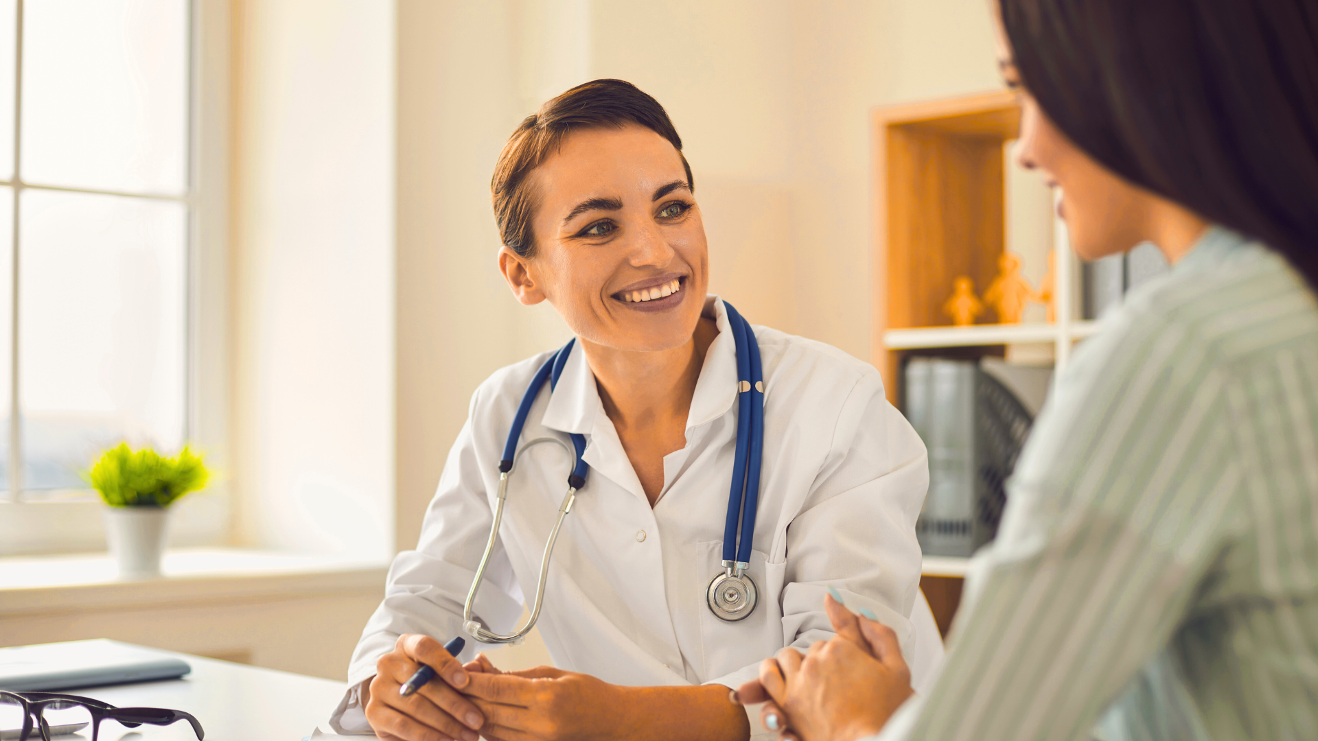 A female doctor is talking to a patient in an office.