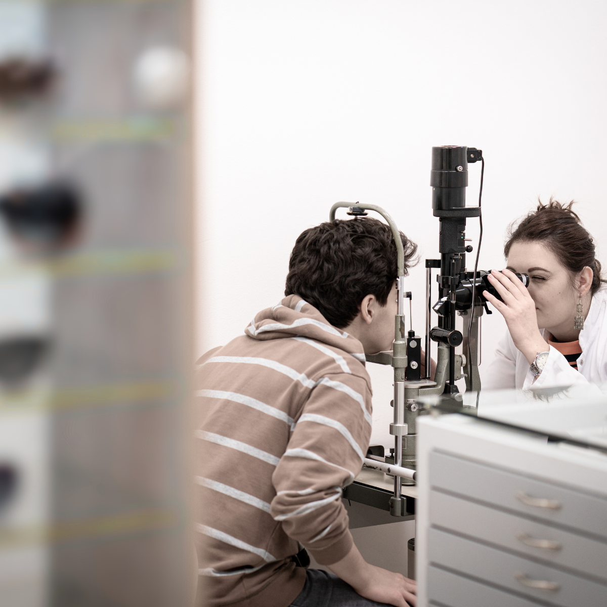 A man and a woman are looking through a microscope