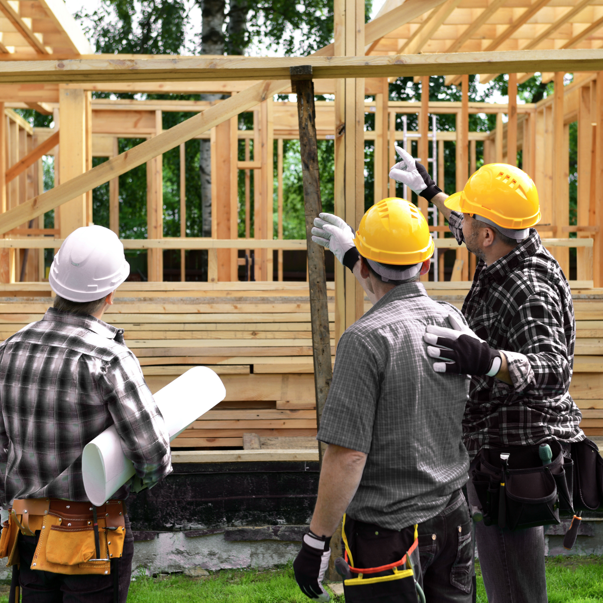 A group of construction workers are standing in front of a wooden structure