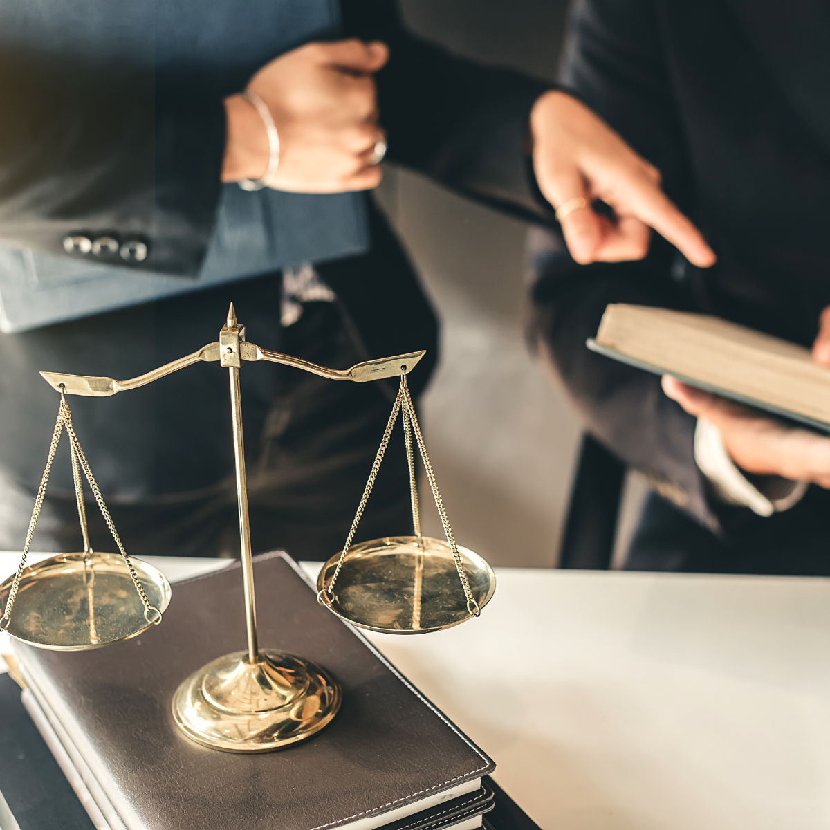 A scale of justice is sitting on top of a stack of books.