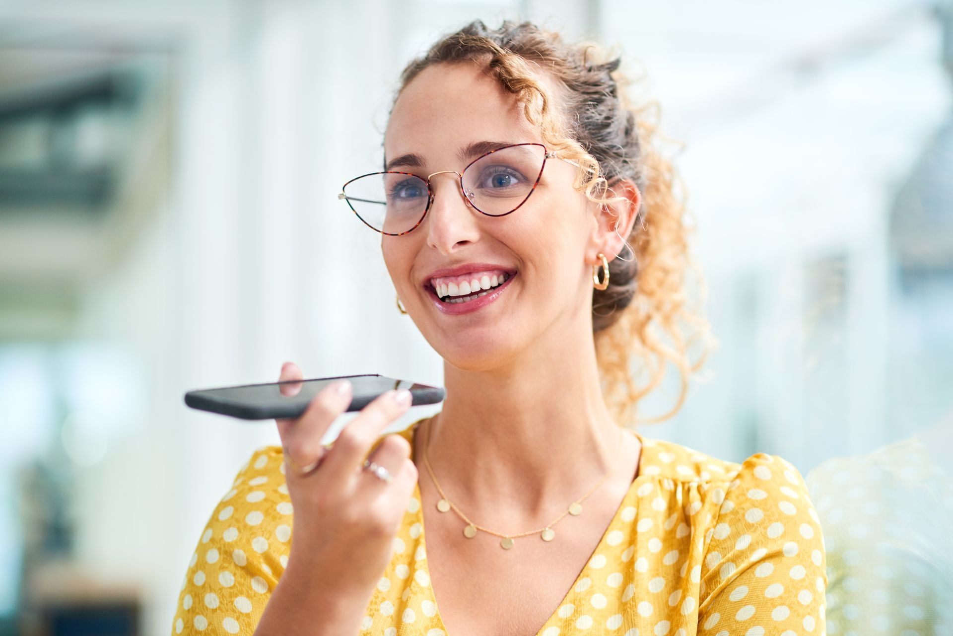 A woman wearing glasses is talking on a cell phone.