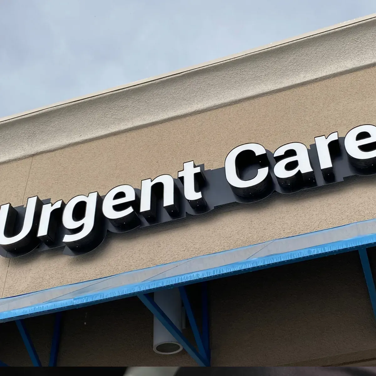 A sign on the side of a building that says urgent care