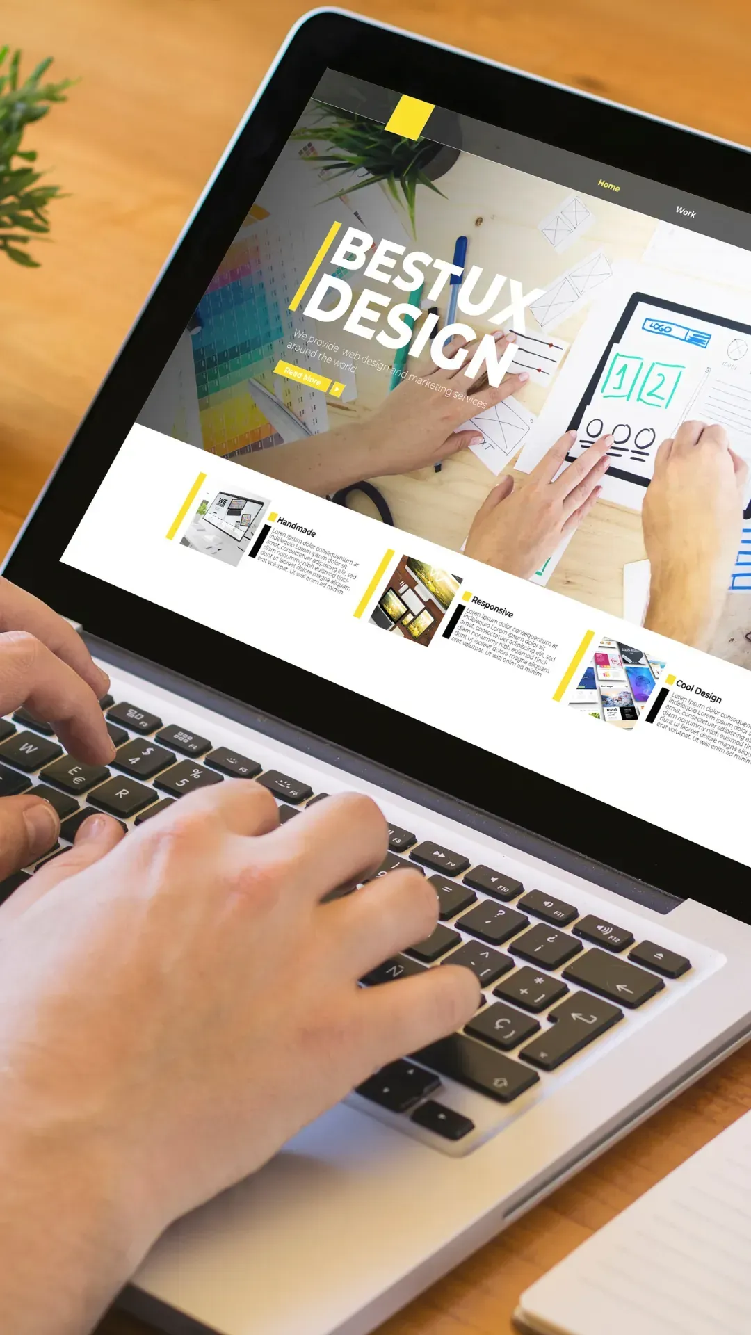 A person is typing on a laptop computer with a website on the screen.