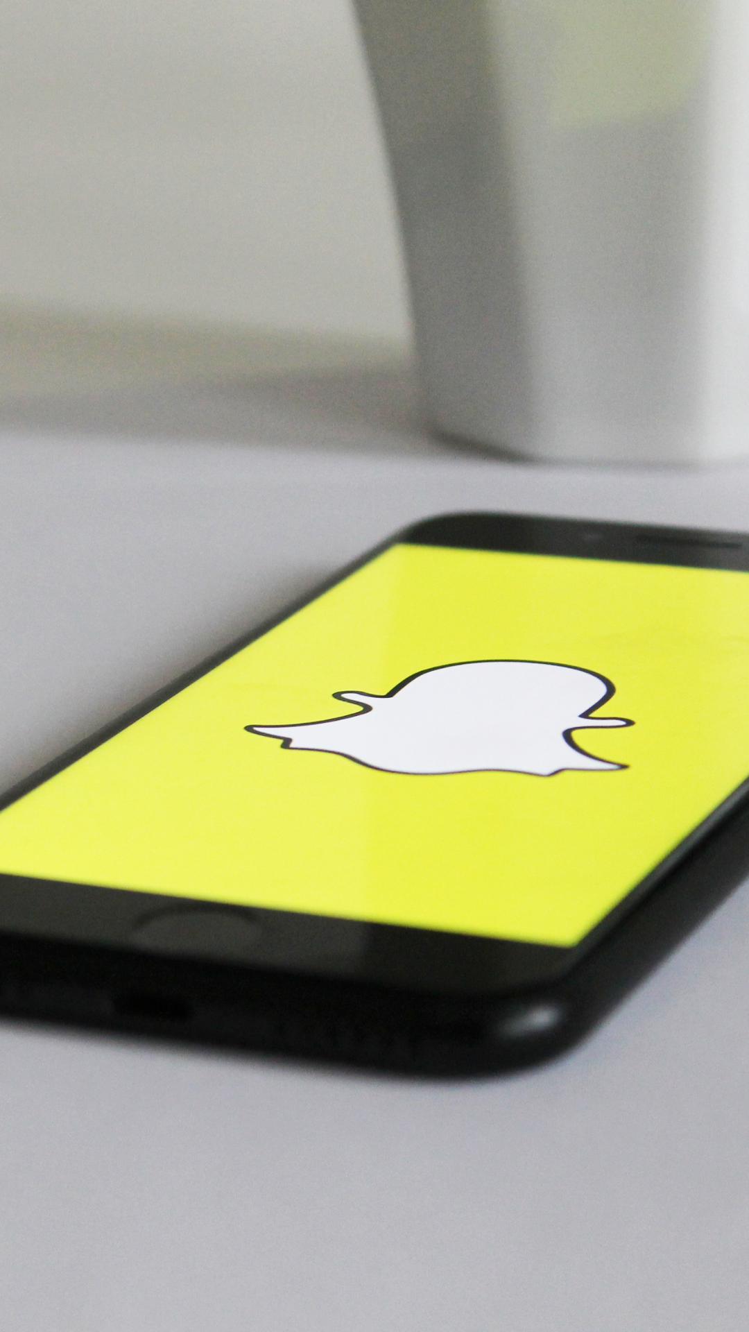 A phone with a snapchat logo on the screen