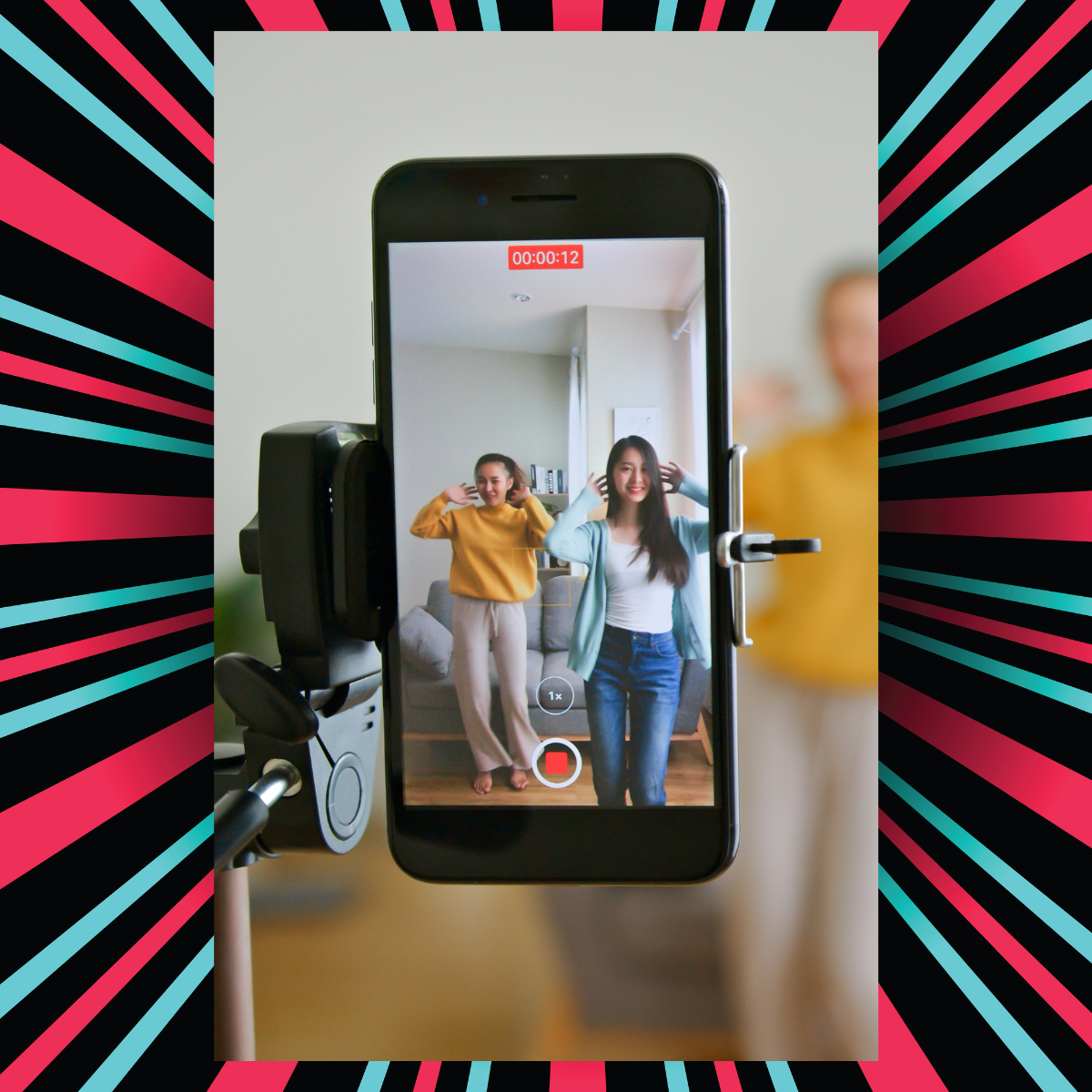 A cell phone is recording a video of two women dancing.