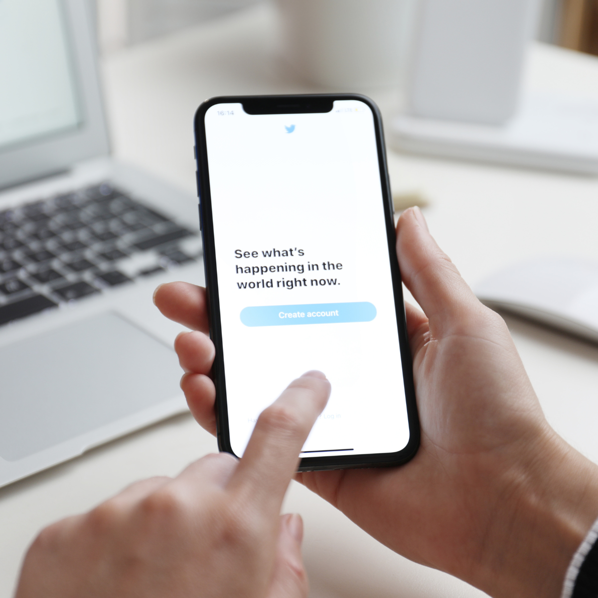 A person is holding a cell phone that says see what 's happening in the word right now
