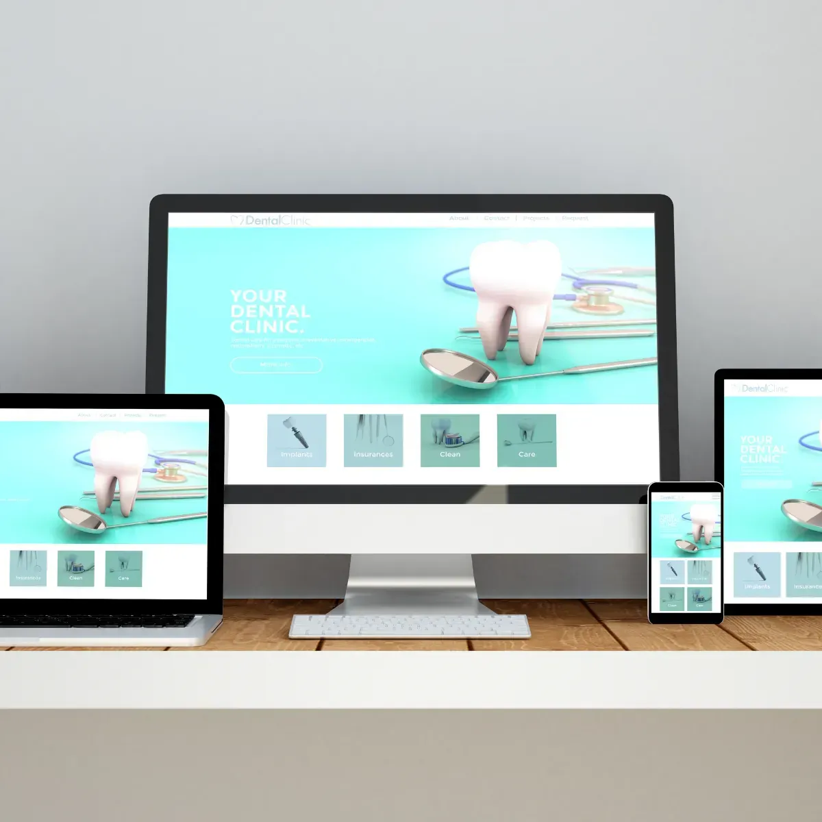 A dental clinic website is displayed on a computer laptop and tablet