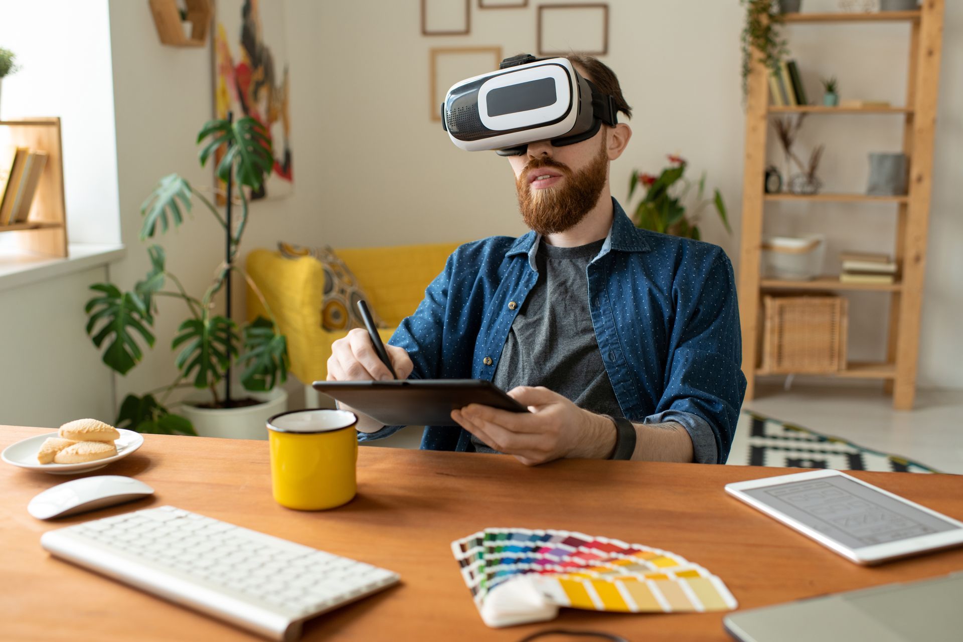 A man is wearing a virtual reality headset while using a tablet.
