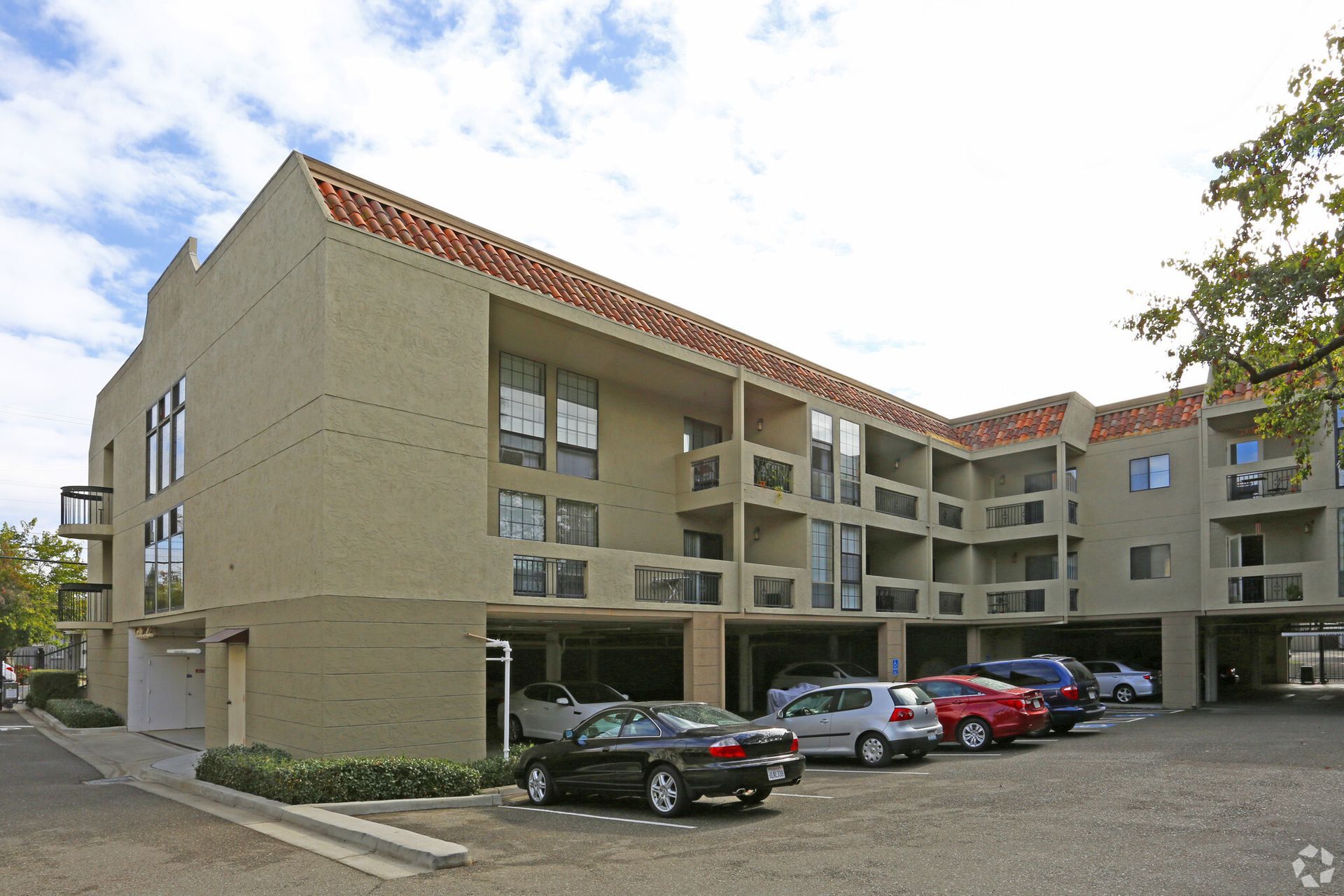 A large apartment building with cars parked in front of it