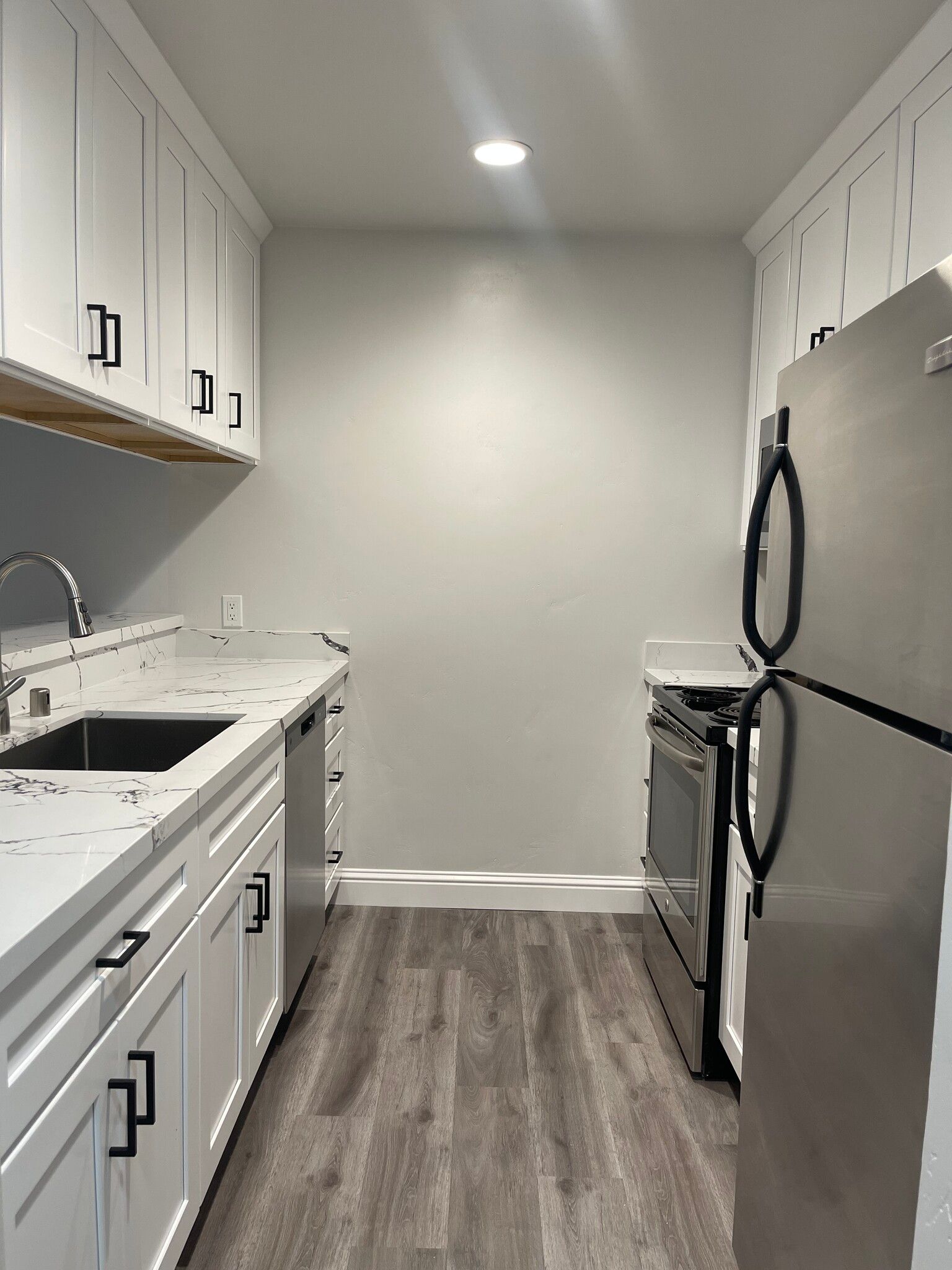 A kitchen with white cabinets and stainless steel appliances