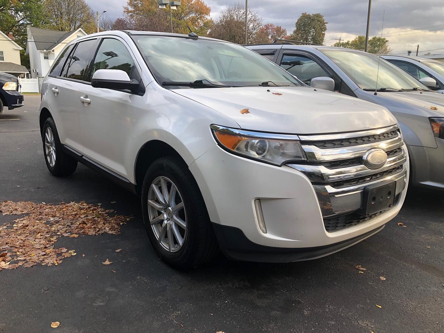 White Ford Edge SUV parked outdoors in a lot on an overcast day.