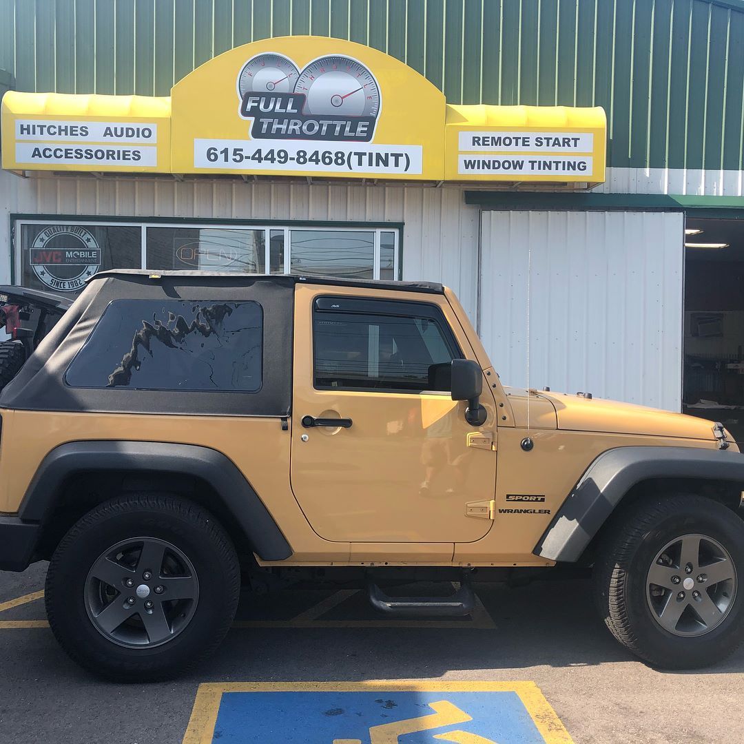 Tan Jeep parked outside a Full Throttle auto accessories and tint shop.