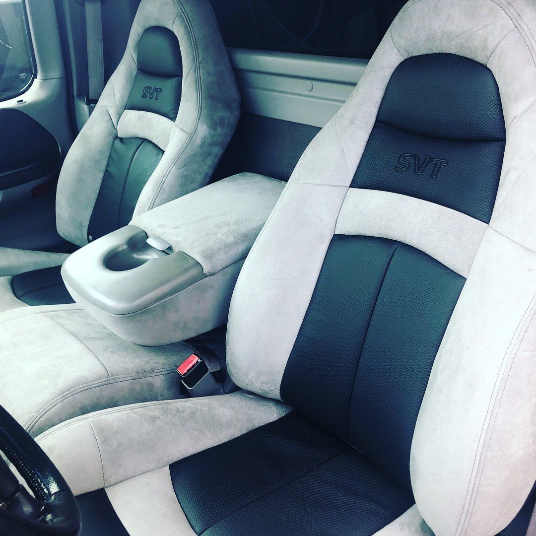 White and black racing-style car seats with a center console in a vehicle interior