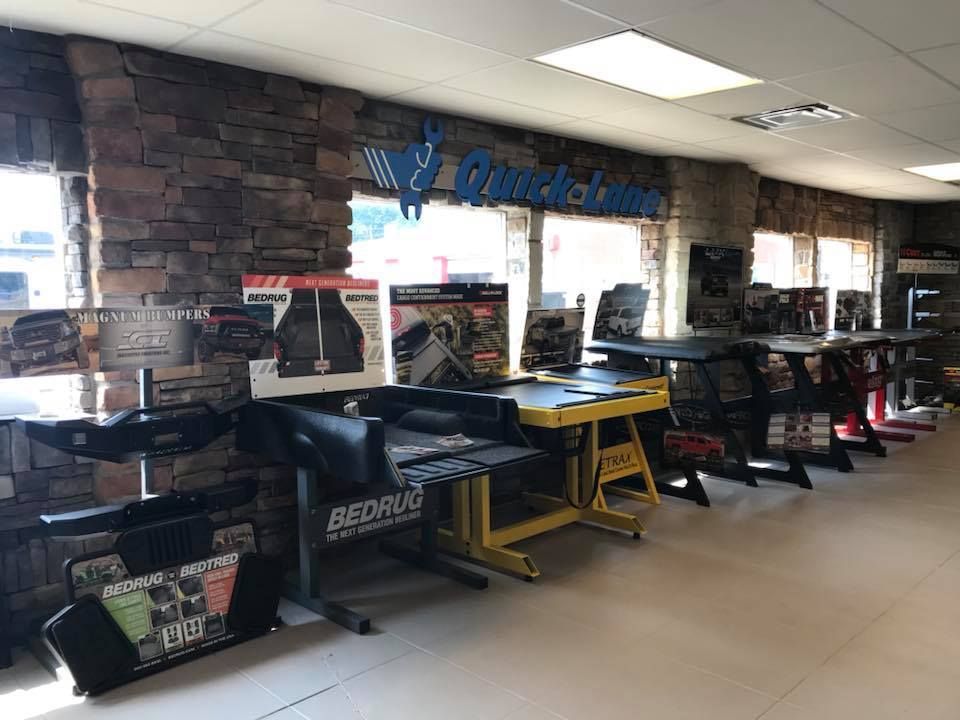 Row of racing arcade machines in a game room with stone walls and bright ceiling lights