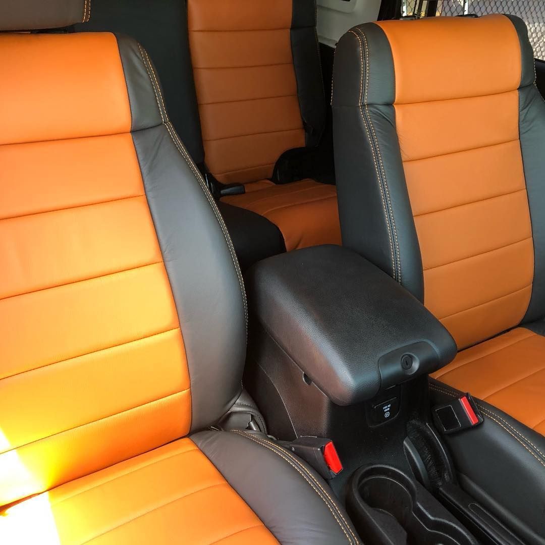 Orange and gray car seats with a black center console in the vehicle interior