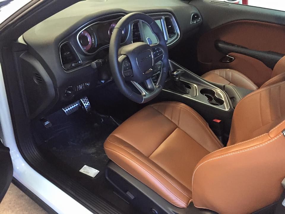 Luxury car interior with brown leather seats, black dashboard, and steering wheel