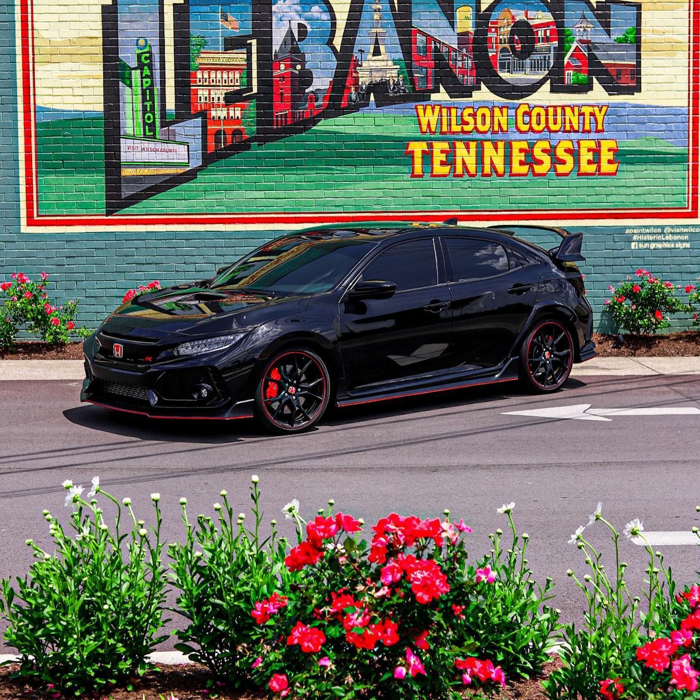 Black sports car parked before a colorful Lebanon, Wilson County, Tennessee mural
