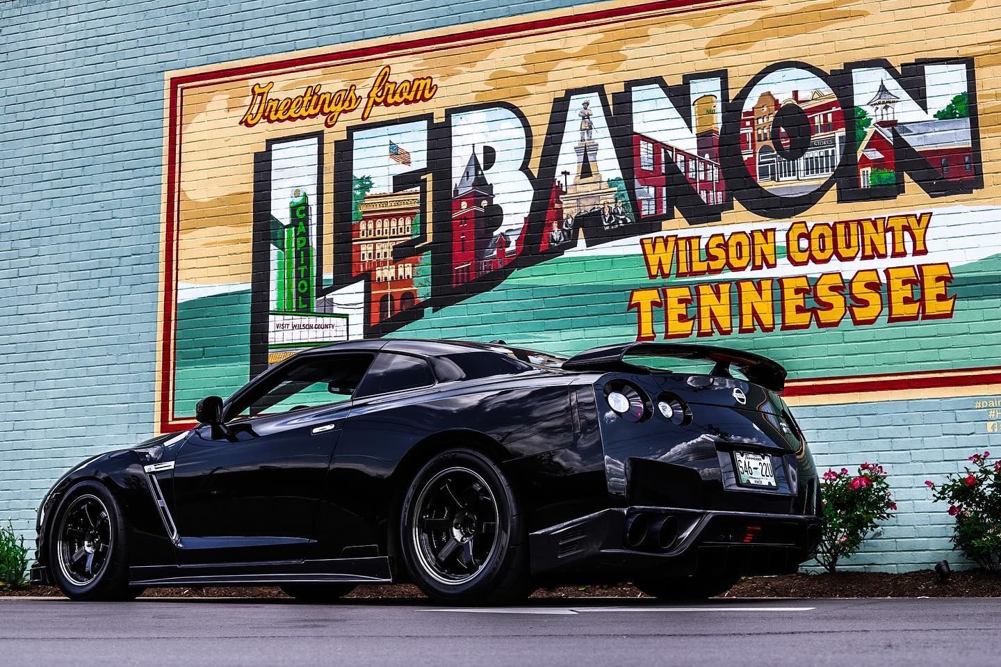 Black sports car parked in front of a colorful mural reading “FRANKLIN Wilson County Tennessee.”