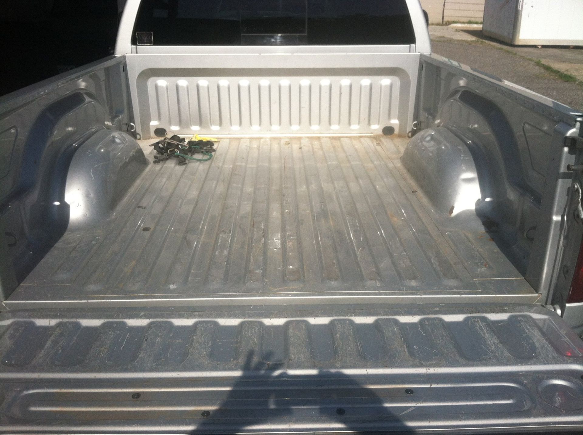 Empty pickup truck bed with a small object near the cab at night