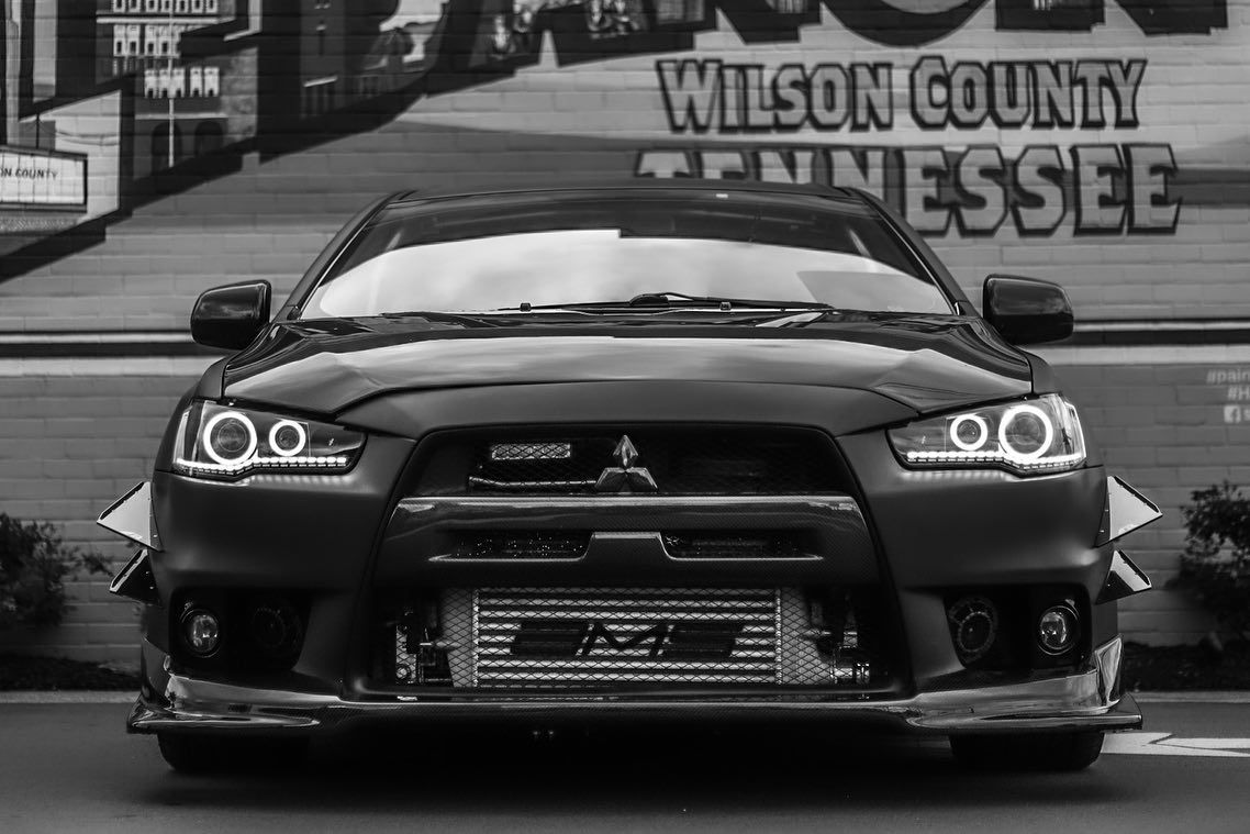 Black sports car parked in front of a Wilson County Tennessee mural