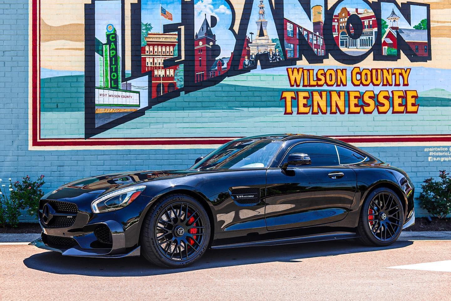 Black sports car parked in front of a colorful Lebanon, Wilson County, Tennessee mural