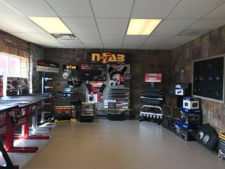 Shop interior with rows of paintball gear, tables, and shelves under bright ceiling lights