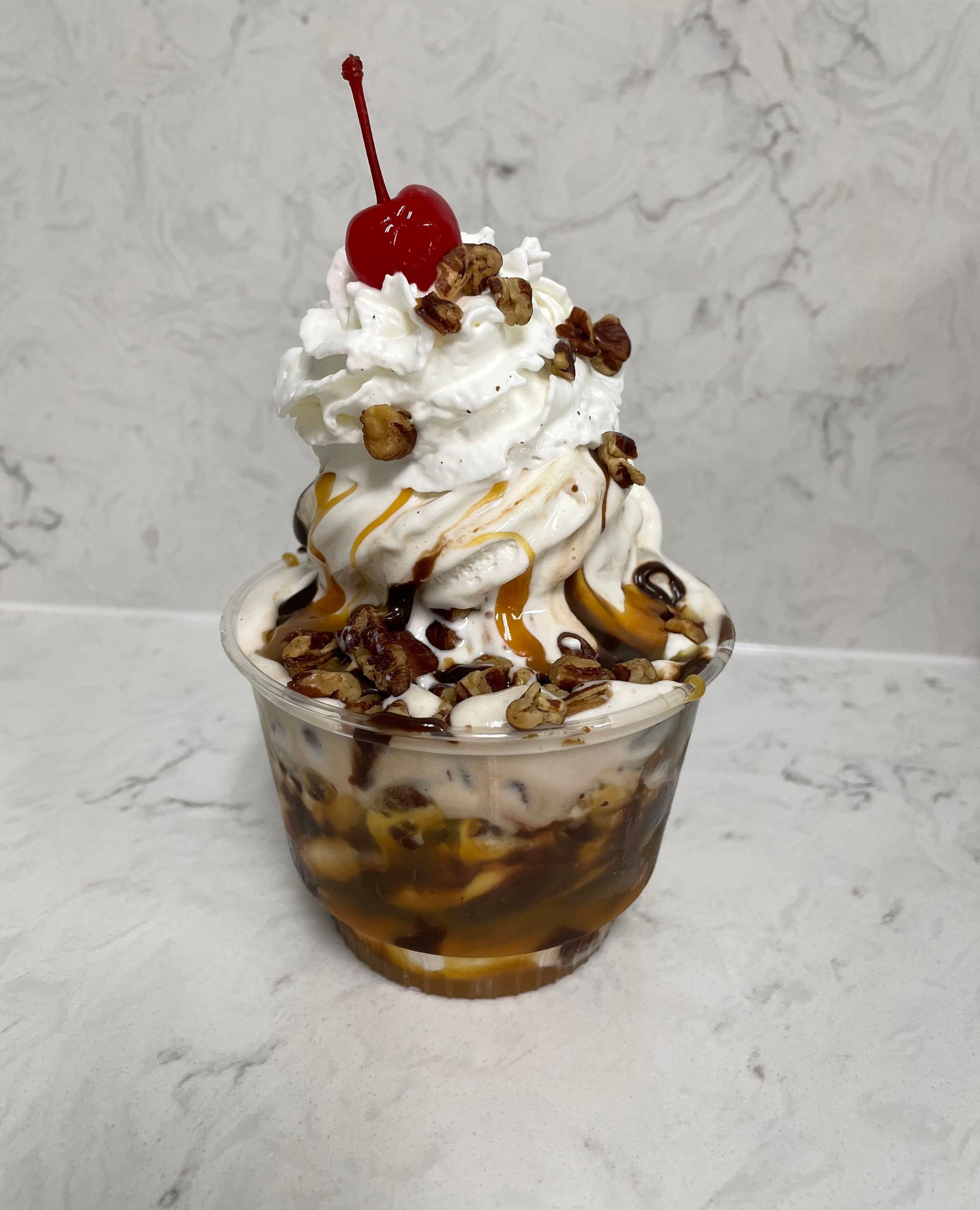 A banana split with whipped cream and a cherry on top