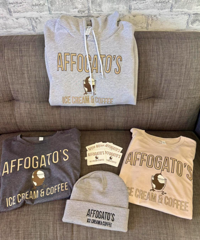 Three affogato 's ice cream and coffee shirts and hats are sitting on a couch.