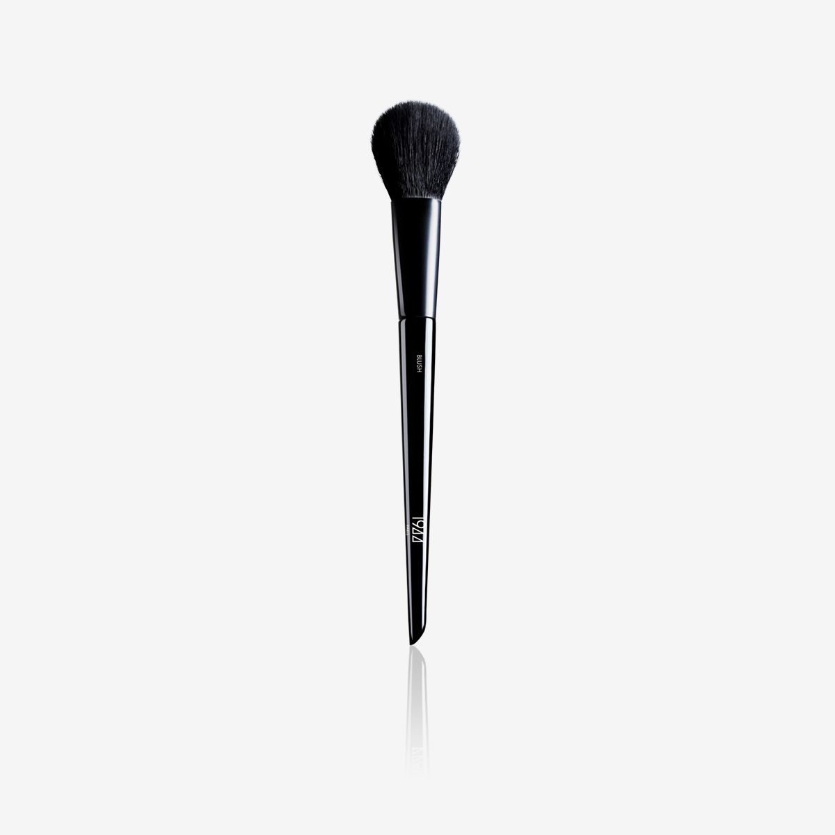 Un pinceau de maquillage noir avec un long manche sur fond blanc.