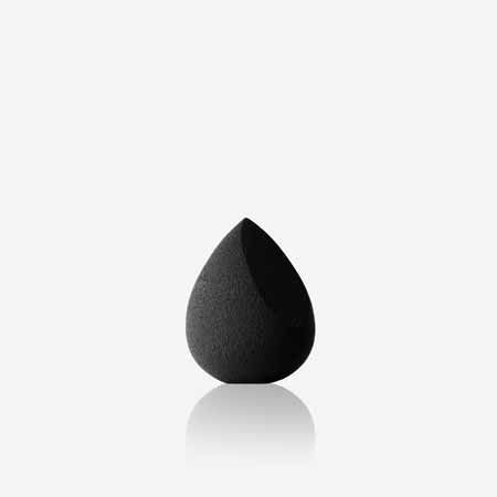 Une éponge noire est posée sur une surface blanche.