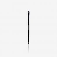 Un pinceau noir est posé sur une surface blanche.