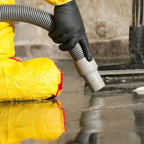 a closeup photo of a professional technician holding the hose end of a water extracting equipment