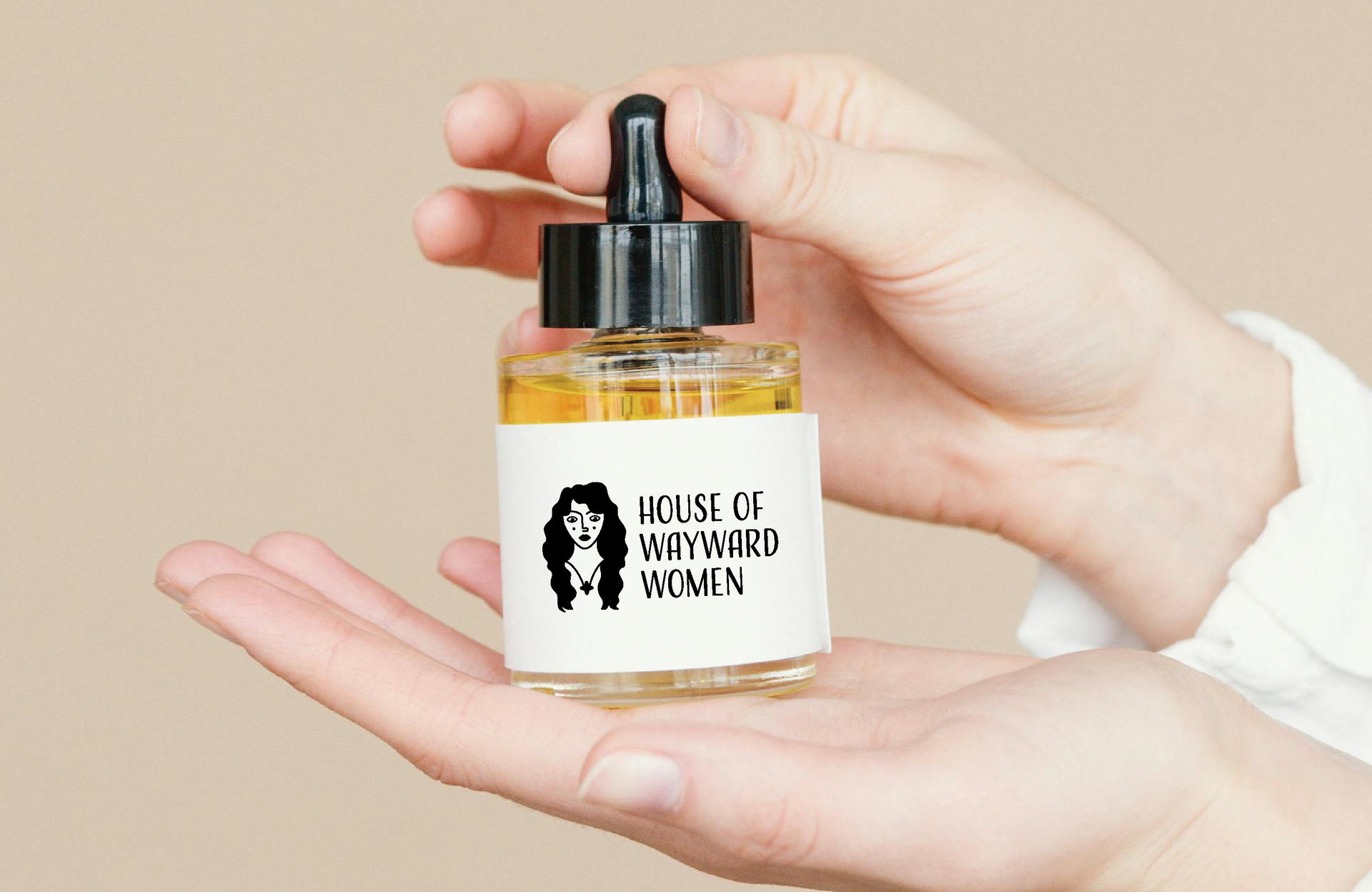 Hands holding a bottle of liquid with a dropper. The label says