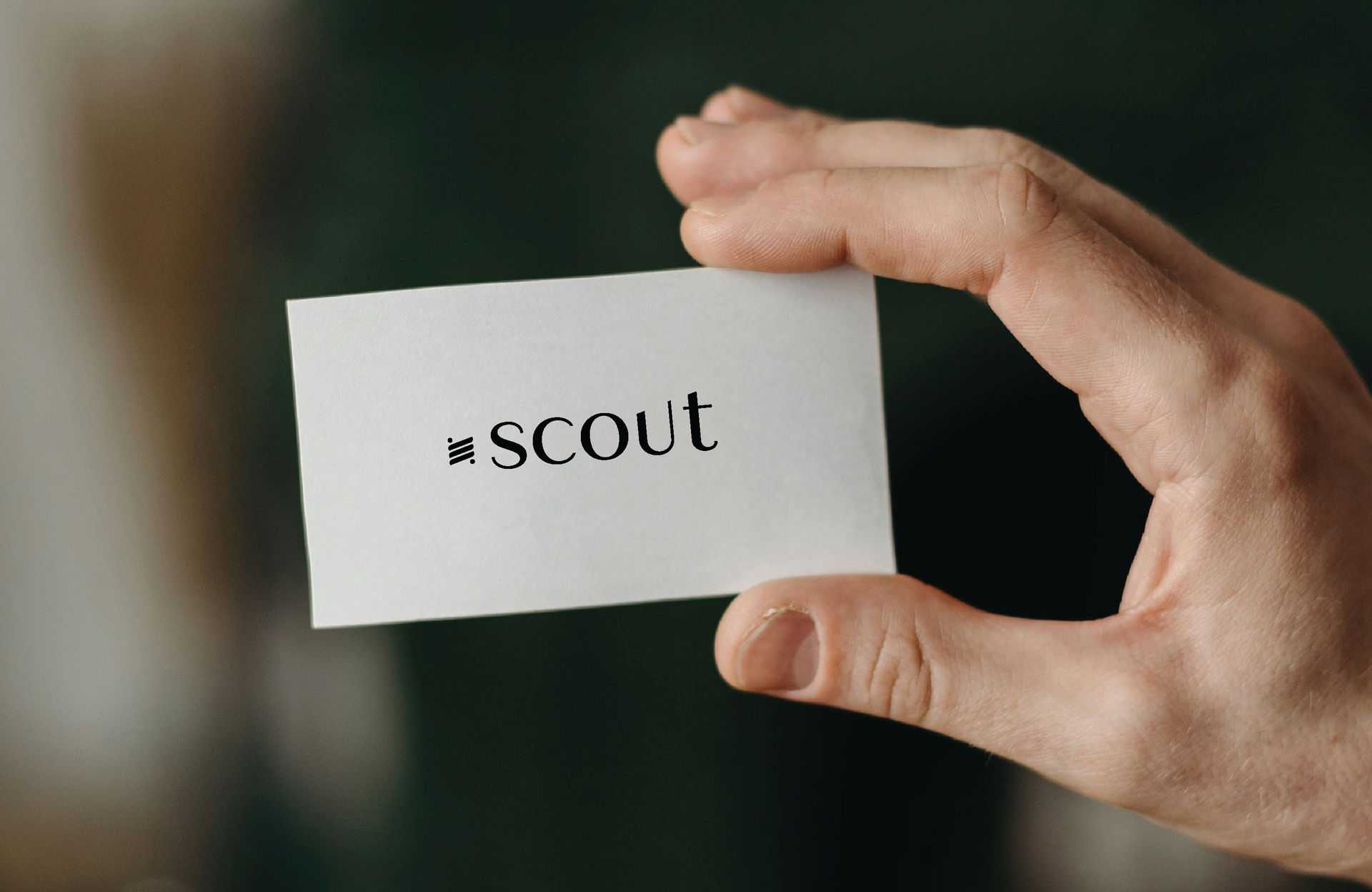 Hand holding a white card with the word