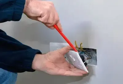 electrician fixing an outlet