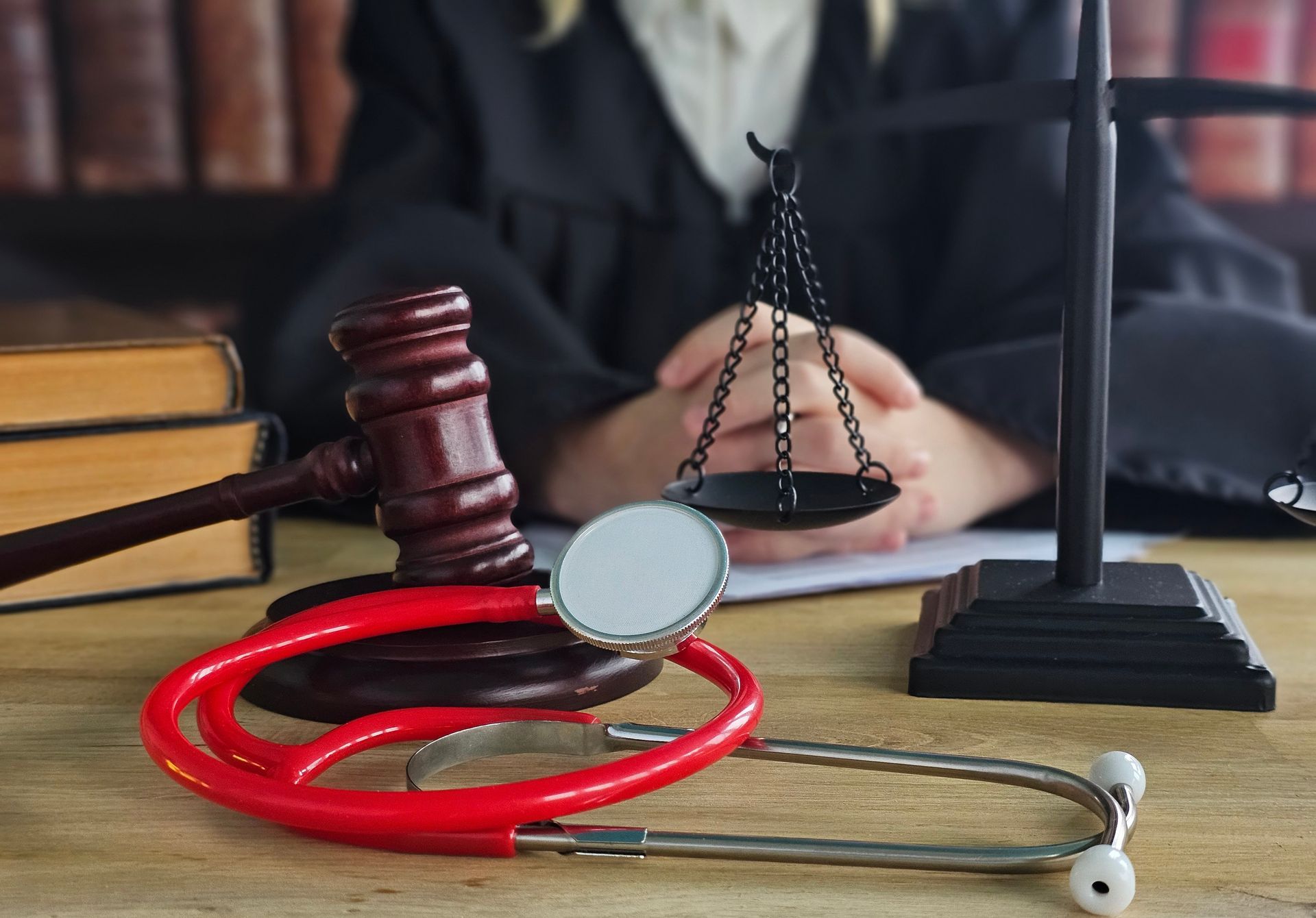 Judge and medical tools on a desk with legal books in the background — Albuquerque, NM — Duhigg, Cronin, Spring & Berlin Judge and medical tools on a desk with legal books in the background — Albuquerque, NM — Duhigg, Cronin, Spring & Berlin