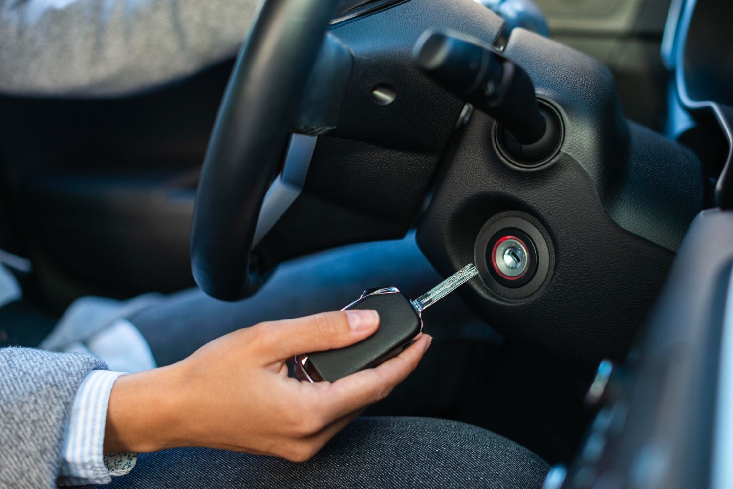 A person is holding a car key in their hand in a car.