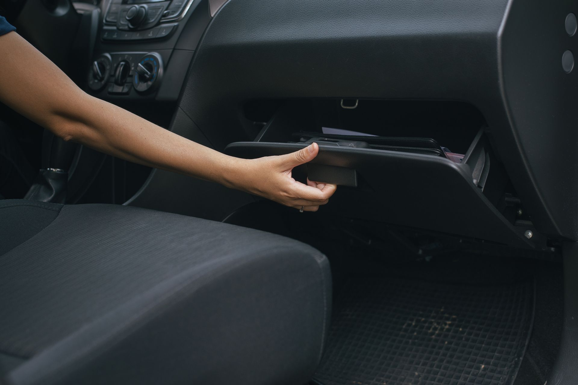 A person is holding a car key in their hand in a car.