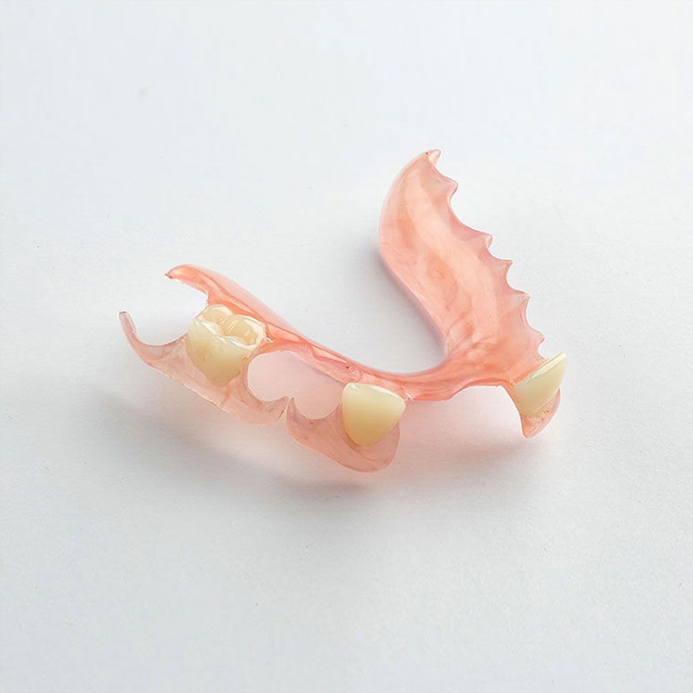 Clear plastic dental mouthguard, with blue and gray detailing on the interior surface, rests on a dark surface.