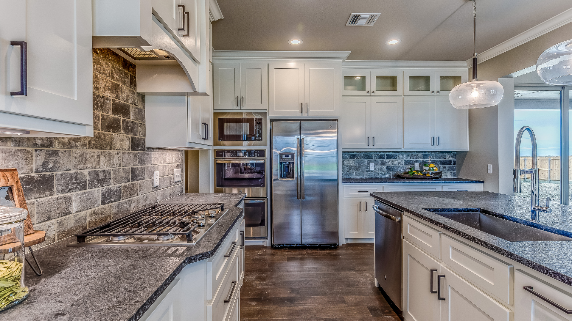 Bright modern kitchen with white cabinets, marble island, barstools, and stainless-steel range hood