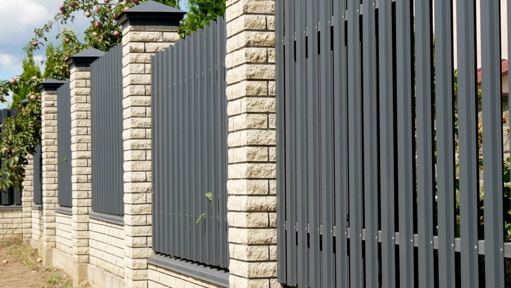 A Close Up Of A Fence With Brick Pillars And A Metal Fence — Tenterfield Timber & Hardware in Glen Innes, NSW