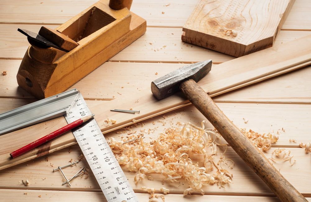 A Wooden Table With A Hammer , Plane , Ruler , Pencil And Wood Shavings — Tenterfield Timber & Hardware in Deepwater, NSW