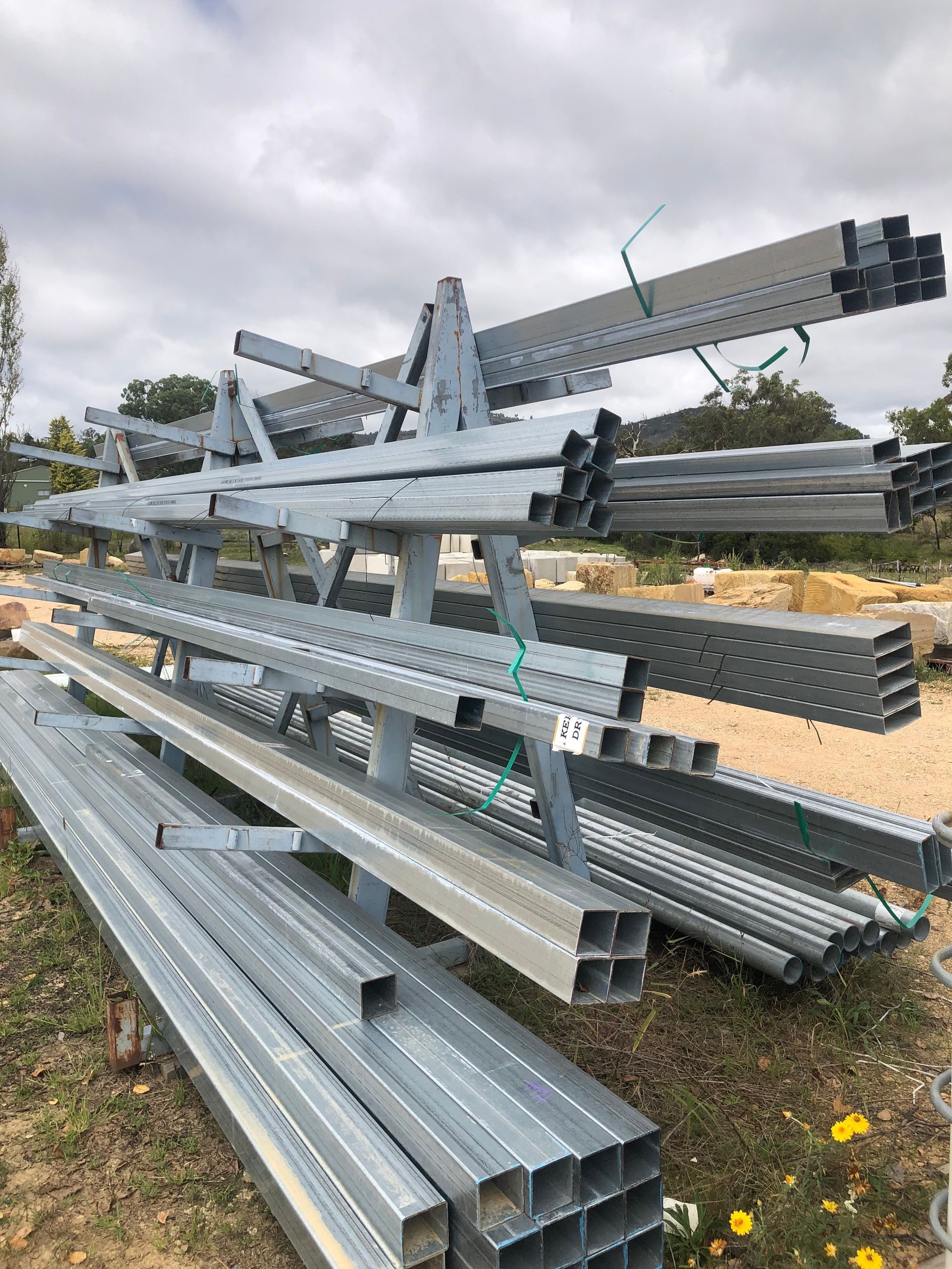 A Bunch Of Metal Pipes Are Stacked On Top Of Each Other — Tenterfield Timber & Hardware in Tenterfield, NSW