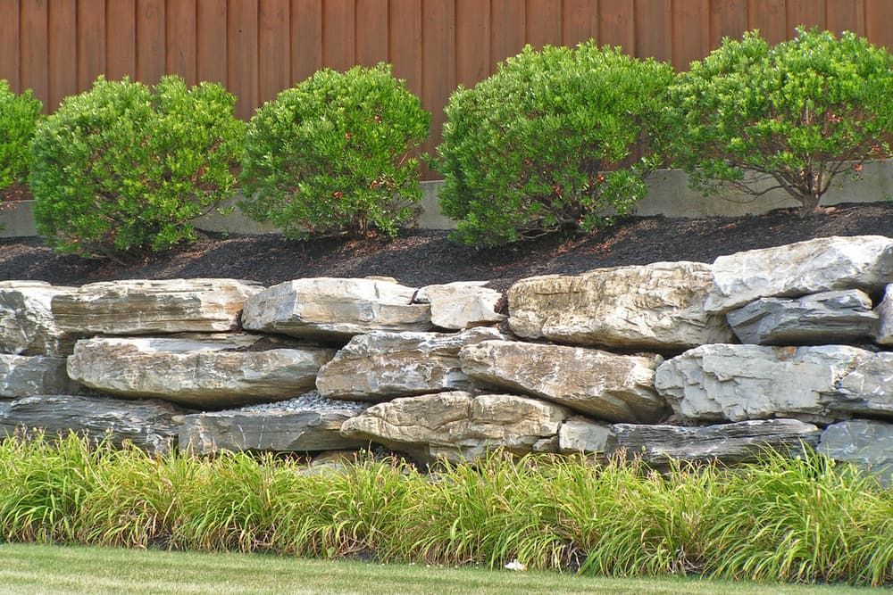 A Large Rock Wall With A Fence In The Background — Tenterfield Timber & Hardware in Tabulam, NSW