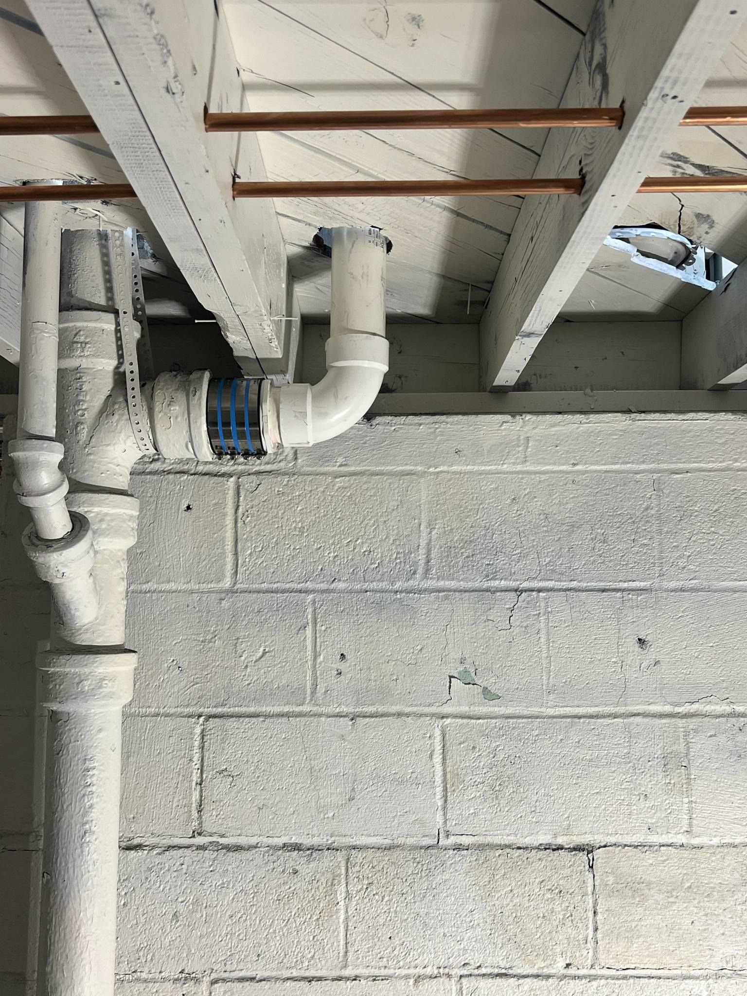 A bunch of pipes are hanging from the ceiling of a building.