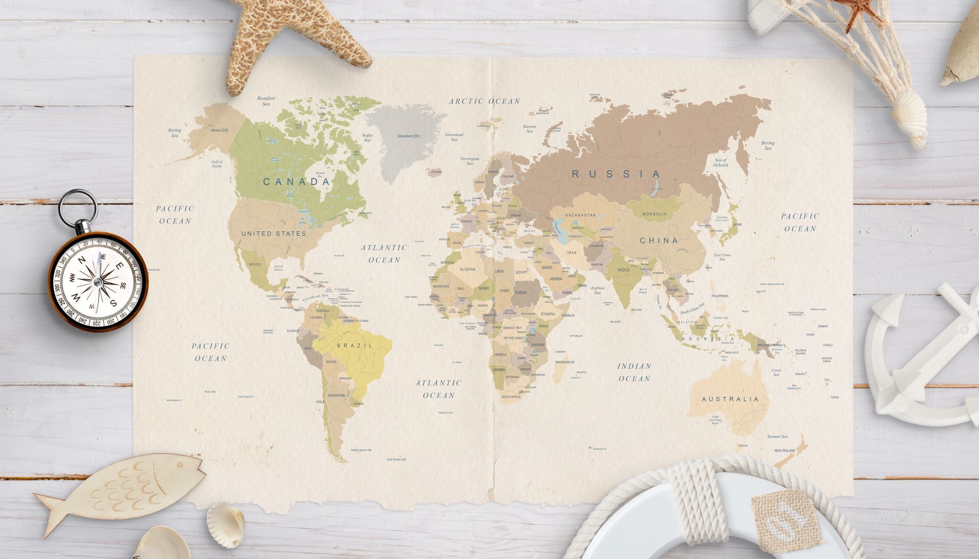 Vintage world map on white wood with compass, starfish, and nautical decor