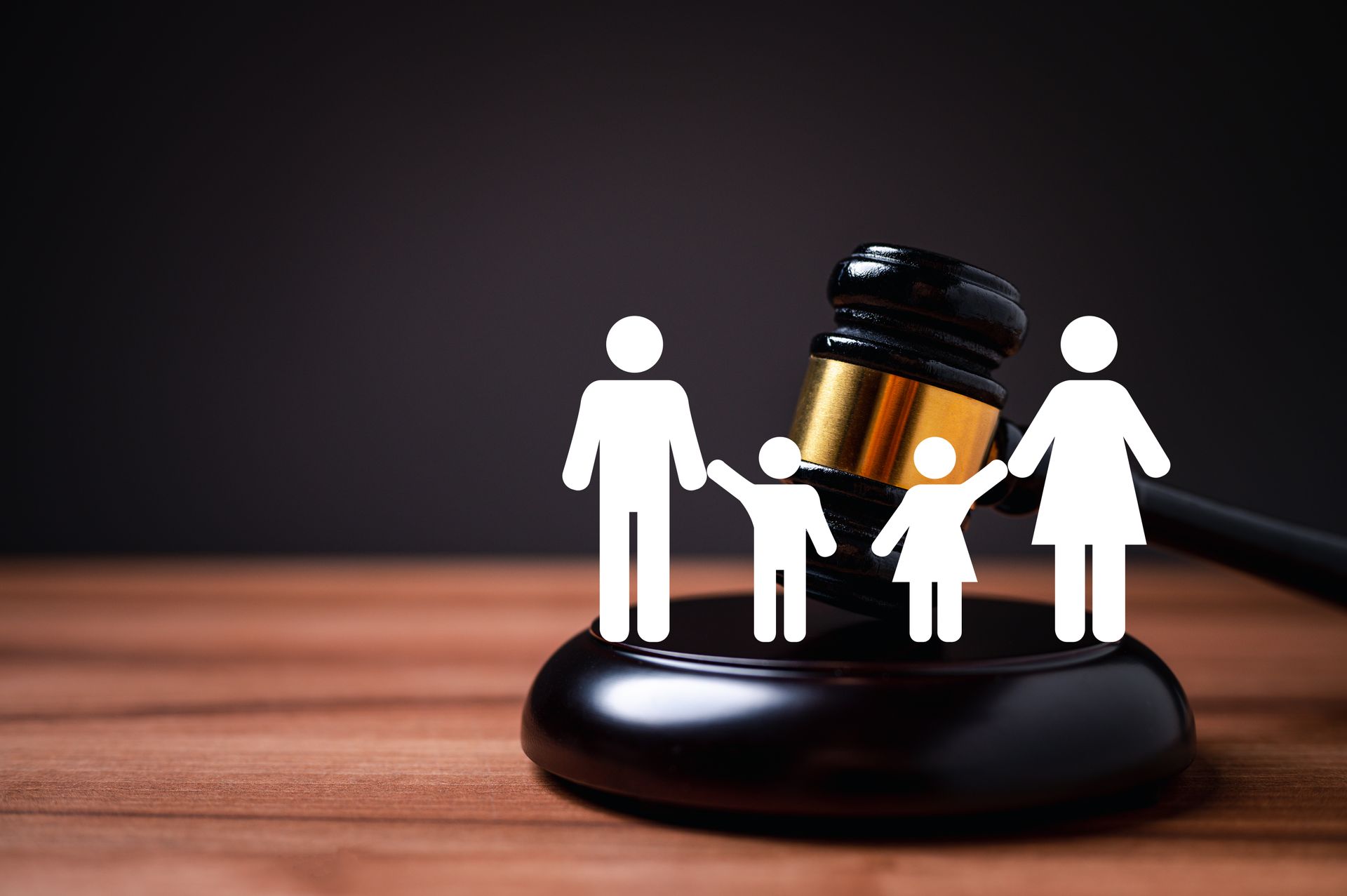 Family silhouettes on a gavel and base, symbolizing legal custody or family law.